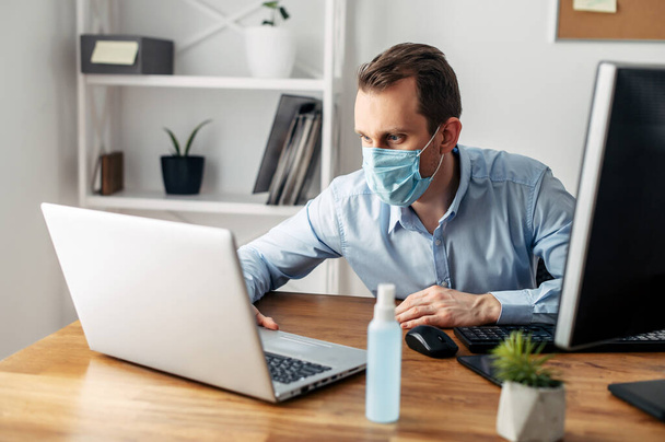 Man in a medical mask at the office - Foto, afbeelding
