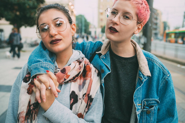 Due giovani donne che camminano all'aperto alla ricerca di fotocamera intimità, ribelle, insieme concetto
 - Foto, immagini