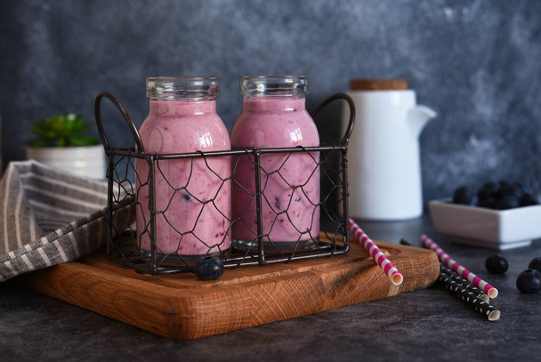 Detox drink. Smoothies with blueberries and yogurt in a glass jar on the kitchen table. - Photo, Image