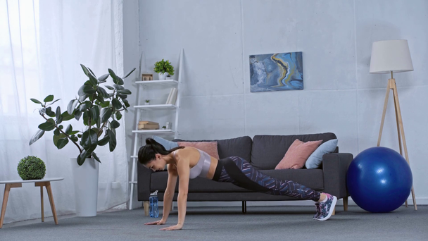 Side view of sportswoman doing push ups at home - Imágenes, Vídeo