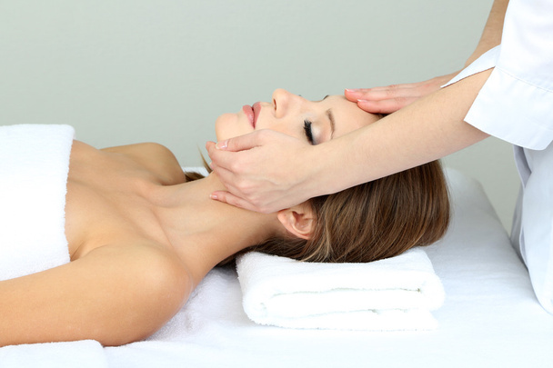 Beautiful young woman during facial massage in cosmetic salon close up - Fotoğraf, Görsel
