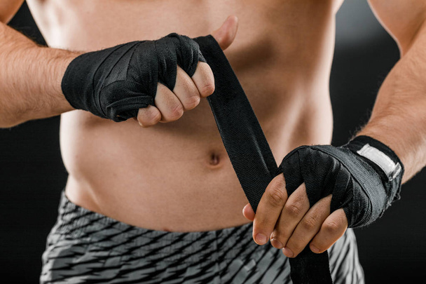 Крупним планом чоловіча боксерська рука з боксерськими бинтами. Кулаки бійця перед бійкою або тренуванням у спортзалі. Концепція спорту
 - Фото, зображення
