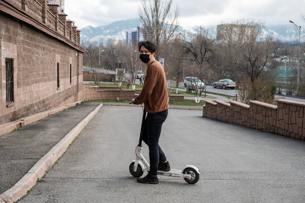 joven montando un scooter en la ciudad - Foto, Imagen