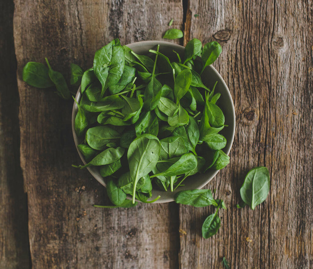 Food. Spinach on a wooden table - Foto, afbeelding