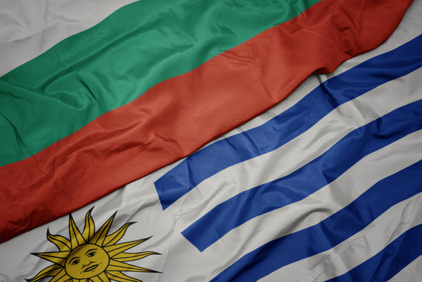 schwenken bunte uruguayische und bulgarische Nationalflaggen. Makro - Foto, Bild