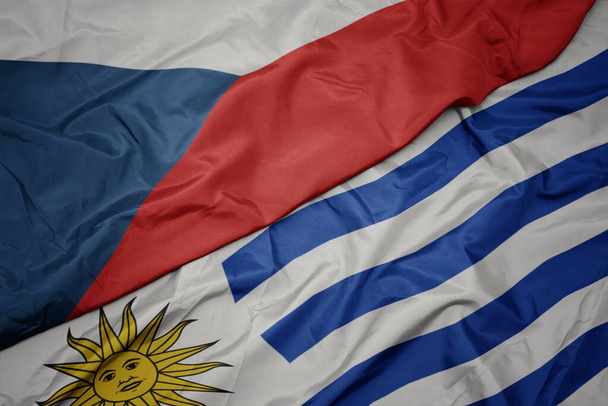 agitando bandeira colorida de uruguai e bandeira nacional da república checa. macro
 - Foto, Imagem
