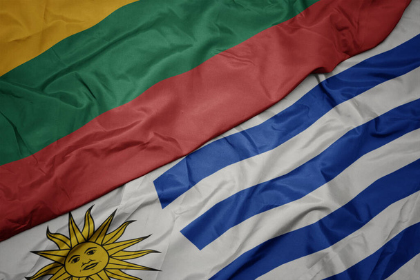 acenando bandeira colorida de uruguai e bandeira nacional de lithuania. macro
 - Foto, Imagem
