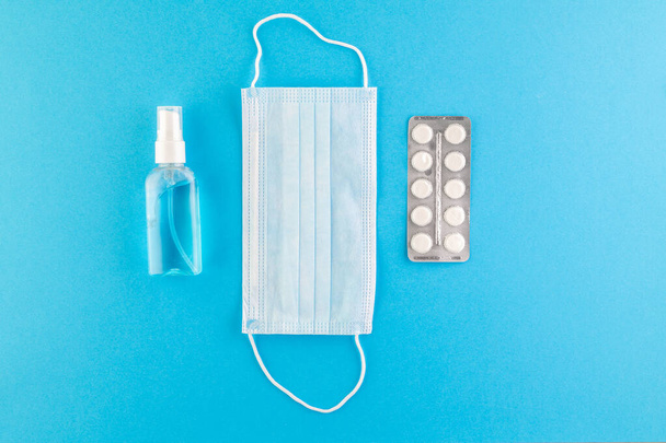 A set of hygienic antiseptics and medications on a blue background. Top view. Antibacterial protection and self-care. Stop the spread of infection. Medical hygiene and virus protection concept.  - Фото, зображення