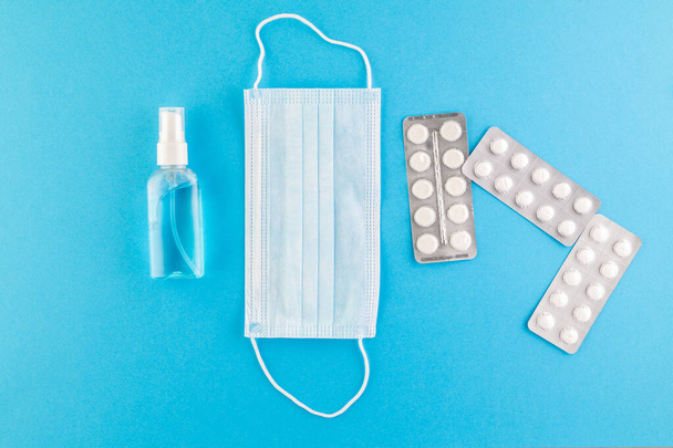 A set of hygienic antiseptics and medications on a blue background. Top view. Antibacterial protection and self-care. Stop the spread of infection. Medical hygiene and virus protection concept.  - Photo, image