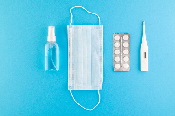 A set of hygienic antiseptics and medications on a blue background. Top view. Antibacterial protection and self-care. Stop the spread of infection. Medical hygiene and virus protection concept.  - Photo, Image