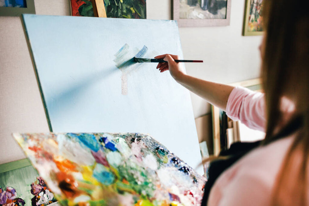 girl artist with a blank canvas draws - Фото, изображение