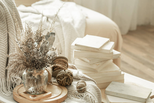 Accueil intérieur confortable de la chambre avec des livres et des fleurs séchées dans un vase. Le concept de divertissement à domicile
. - Photo, image