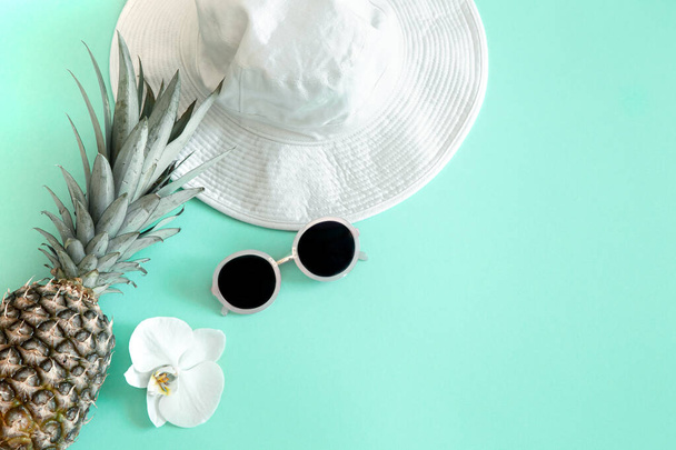 Colorido traje de moda femenina de verano plano-lay.White elegante sombrero de mujer con gafas de sol y piña fresca. Moda de verano o concepto de viaje de vacaciones
 - Foto, Imagen