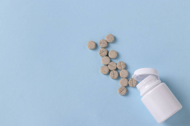 Гомеопатические таблетки от кашля, слизь в банке на синем фоне, вид сверху, пространство для копирования
 - Фото, изображение