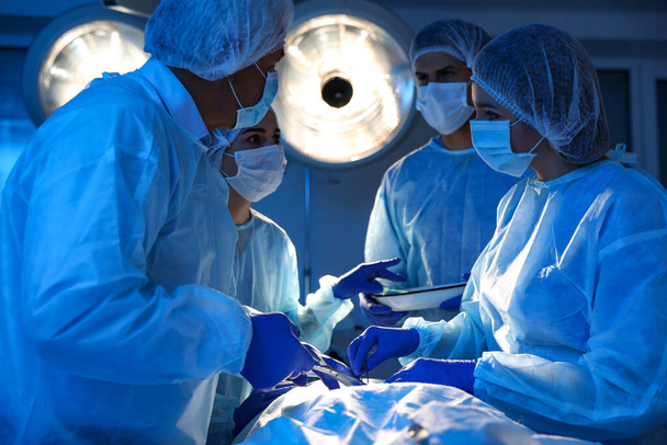 Zespół profesjonalnych lekarzy wykonujących operacje na sali operacyjnej - Zdjęcie, obraz