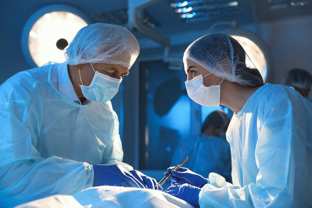 Equipo de médicos profesionales que realizan operaciones en sala de cirugía - Foto, imagen