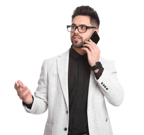 Young businessman talking on smartphone against white background - Photo, image