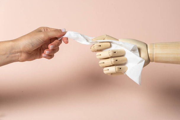 Illness and allergy disease concept. Cropped view of sick young adult woman take white napkin from wooden mannequin hand isolated on pastel pink background with copy space - Fotó, kép