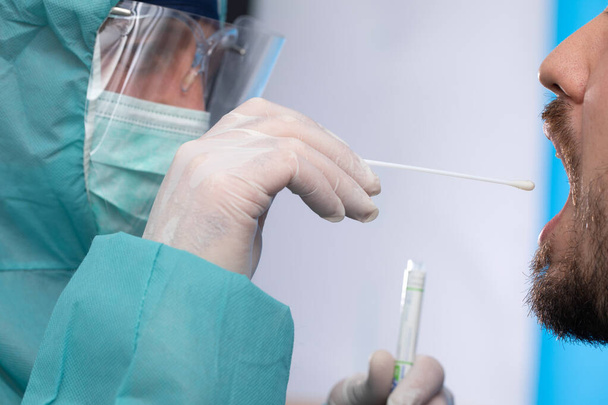 lekarz pobierający próbkę testową śliny - Zdjęcie, obraz
