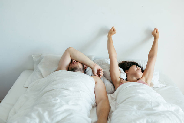couple sleeping in bed with white sheets copy space - Foto, afbeelding