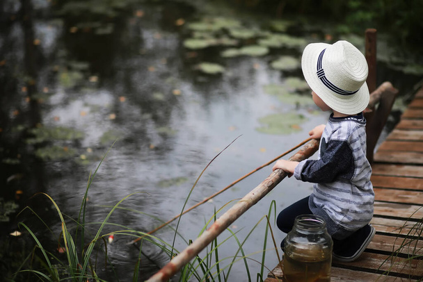 Jeunes éclaireurs. Enfants en voyage de camping. Poisson pour la pêche sur un étang et une rivière. Vacances de grand-mère dans le village
. - Photo, image