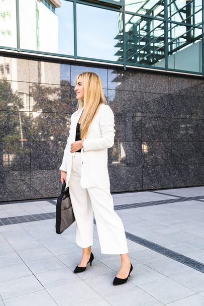 外の白いスーツを着た若いビジネス女性 - 写真・画像