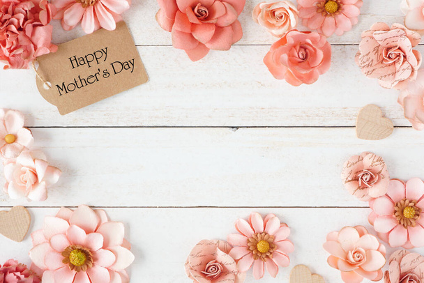 Happy Mothers Day frame with pink paper flowers and gift tag. Top view against a white wood background. Copy space. - Photo, Image