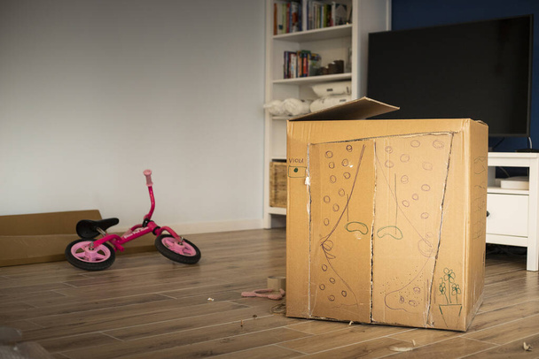 Creëren van een kartonnen speelhuisje tijdens het verhuizen naar een nieuw huis. - Foto, afbeelding
