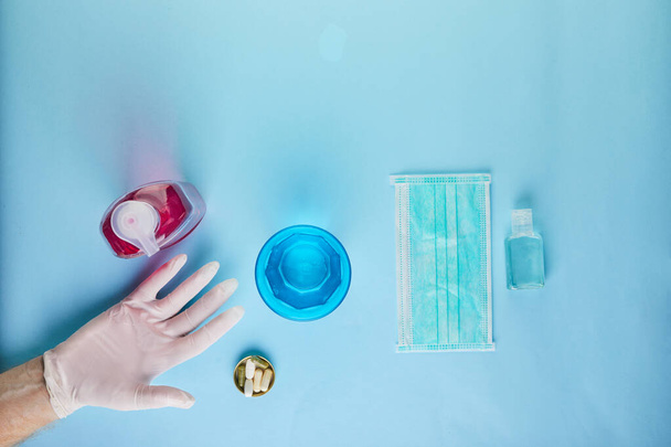 Η έννοια του coronavirus COVID-19, Πώς να προστατεύσετε τον εαυτό σας από τη μόλυνση. Πλένεται στο χέρι, τη μάσκα και τα δισκία. Επίπεδη τοποθέτηση σε μπλε φόντο. - Φωτογραφία, εικόνα