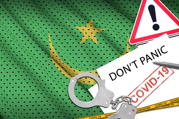 Mauritanian lippu ja poliisin käsiraudat kirjoituksella Älä panikoi valkoisella paperilla. Coronavirus tai pandemia 2019-nCov-viruskonsepti
 - Valokuva, kuva