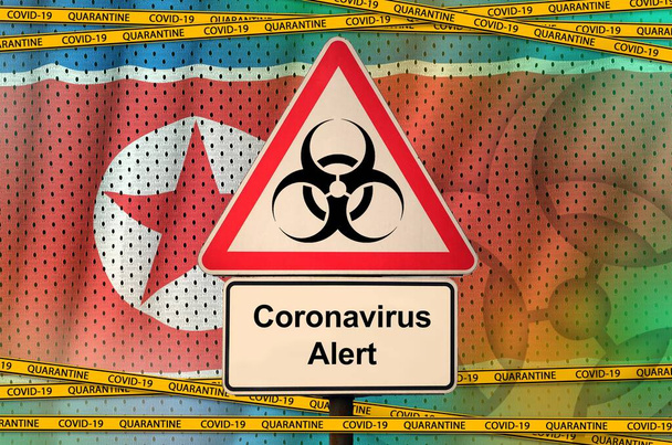 North Korea flag and Covid-19 biohazard symbol with quarantine orange tape. Coronavirus or pandemic 2019-nCov virus concept - Photo, Image