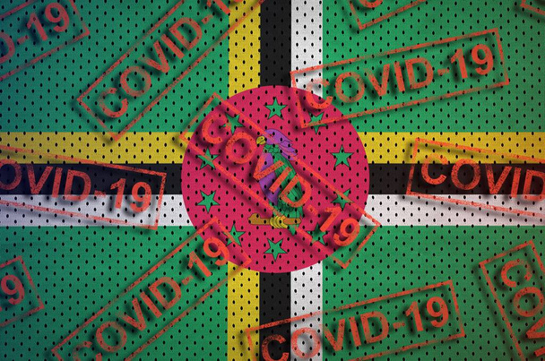 Bandera de Dominica y muchos sellos Covid-19 rojos. Concepto de Coronavirus o pandemia 2019-nCov virus
 - Foto, Imagen