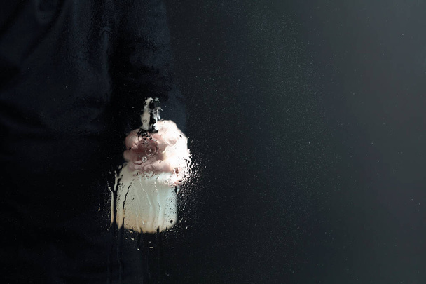 Mann in Gummihandschuhen sprüht Desinfektionsmittel auf ein Glas, selektiver Fokus. Kopierraum. - Foto, Bild