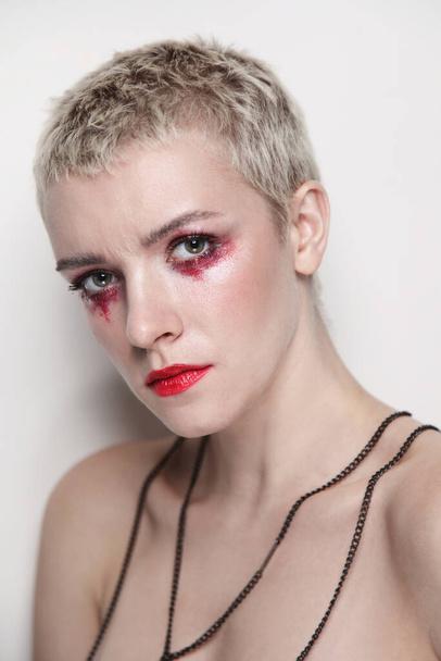 Young beautiful woman with short haircut and fancy red makeup - Foto, afbeelding