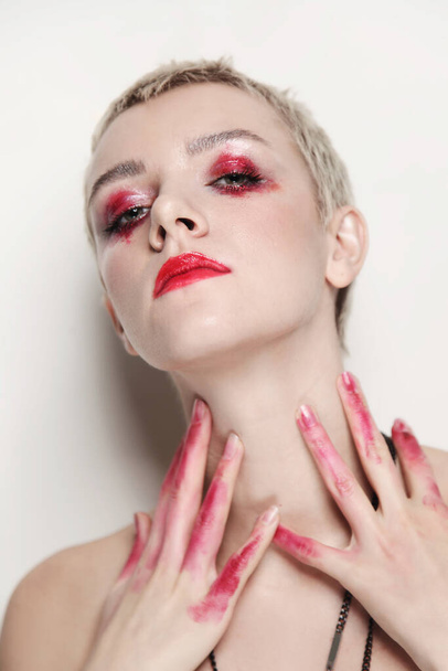 Young beautiful woman with short haircut and fancy red makeup - Photo, Image