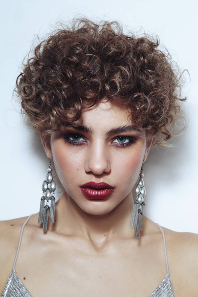 Portrait of young beautiful girl with curly hair and smoky eye makeup - Foto, imagen