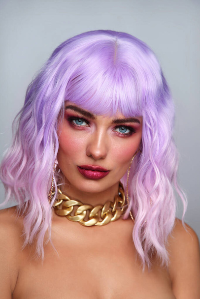Potrait of young beautiful tanned woman with lilac hair and bright fancy makeup - Фото, зображення