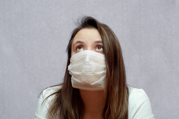 sick woman in a medical mask. sad eyes close up. portrait - Photo, Image