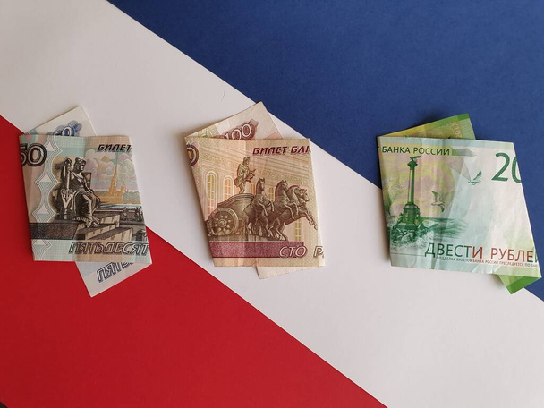 Rosyjskie banknoty o różnych nominałach na tle banknotów w kolorze białym, niebieskim i czerwonym - Zdjęcie, obraz