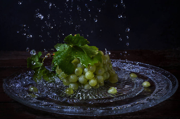 green grapes and spray on a dark background - Фото, изображение
