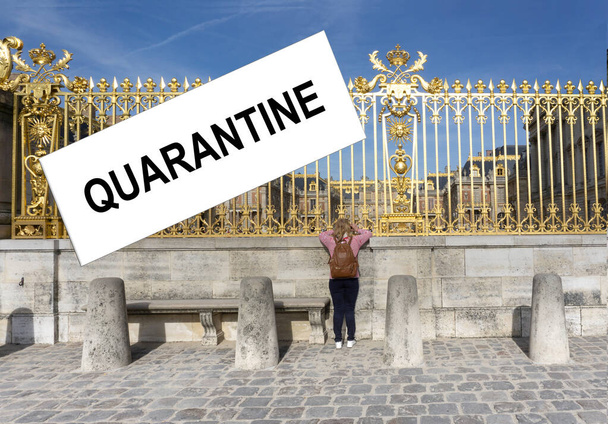 View of a long museum fence with gilding. A girl looks through the bars in a closed museum. Quarantine concept for the global coronovirus pandemic. White quarantine label. - Photo, Image