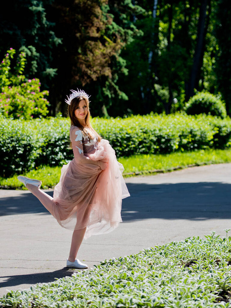 Lovely girl posing in a dress at the park's alley. - Foto, immagini