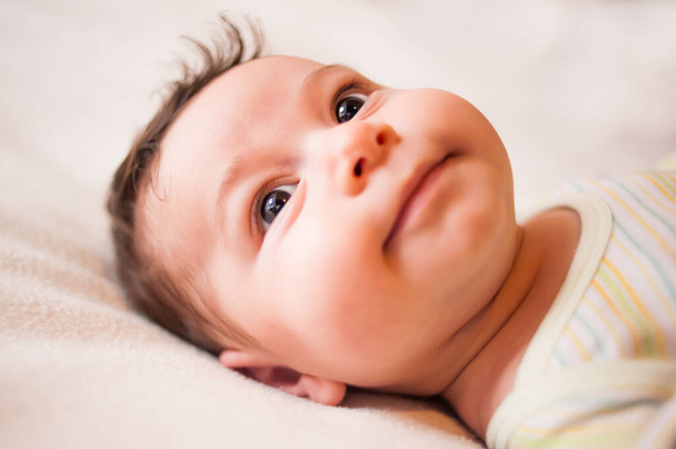 νεογέννητο όμορφο μωρό closeup πρόσωπο στο κρεβάτι. - Φωτογραφία, εικόνα