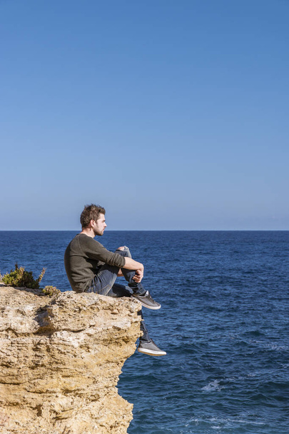 Malta Gozo, Giovane che guarda l'oceano in una giornata luminosa a Gharb, Malta Gozo
 - Foto, immagini