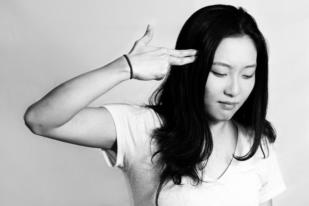 jonge vrouw wijzend vingers op haar hoofd - Foto, afbeelding