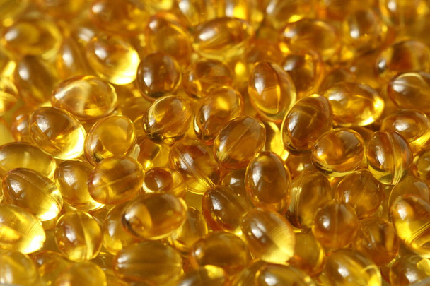 Kultaiset taustakapselit Lähikuva ravintolisä öljy täynnä kapseleita sopiva vitamiini, D3-vitamiini, kalaöljy, omega 3, 6, 9, ilta primrose, borage öljy, pellavansiemenöljy, D-vitamiini, E-vitamiini
. - Valokuva, kuva