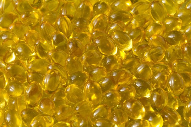 Capsules de fond dorées Fermer Capsules remplies d'huile alimentaire appropriées vitamine A, vitamine D3, huile de poisson, oméga 3, 6, 9, onagre, huile de bourrache, huile de lin, vitamine D, vitamine E
. - Photo, image
