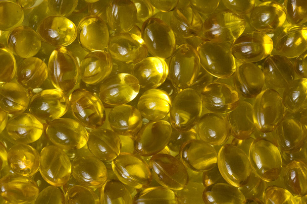 Золотий фон капсули Крупним планом харчова добавка олія наповнена капсулами підходящий вітамін А, вітамін D3, риб'ячий жир, омега-3, 6, 9, вечірні проростки, борошняна олія, насіння льону олія, вітамін D, вітамін Е
. - Фото, зображення