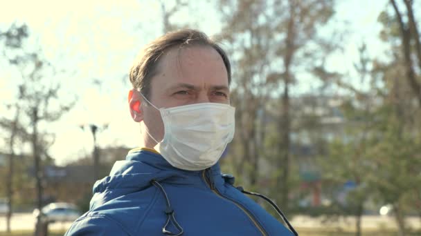 Egy férfi turista portréja, aki védőmaszkot visel egy parkban az utcán. vírusok és baktériumok elleni védelem. egészségvédelmi és biztonsági koncepció, N1H1 koronavírus egészségvédelmi és biztonsági koncepció. Influenzajárvány. - Felvétel, videó