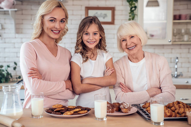 Tytär, äiti ja isoäiti ruoanlaitto keittiössä. Naisten sukupolvi leipoo yhdessä
 - Valokuva, kuva